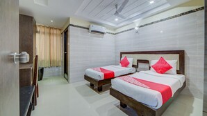A hotel room with two beds, a ceiling fan, an air conditioning unit, and a bathroom with a shower and toilet. - OYO Flagship 24397 9 Star Hotel (Hyderabad)
