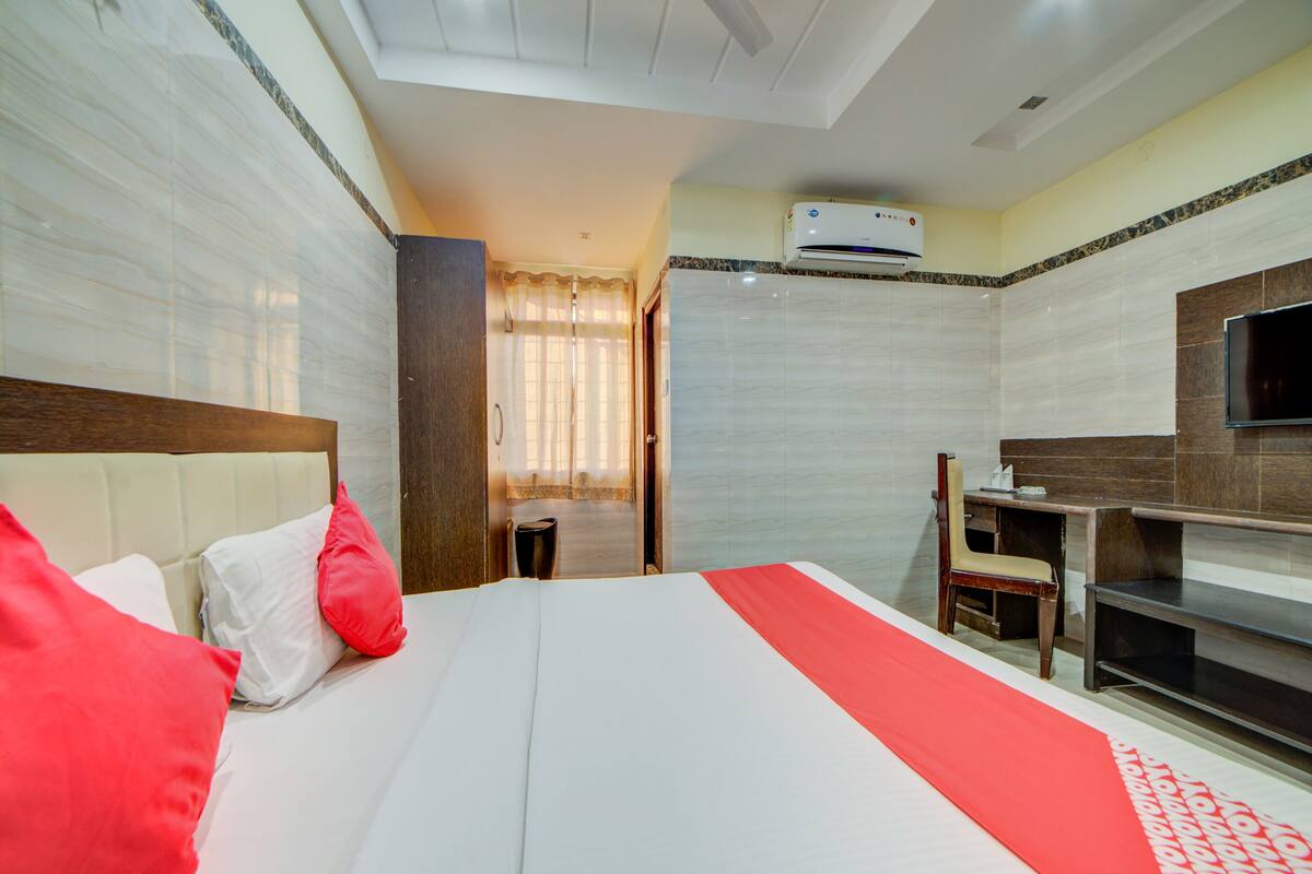 Habitació d'hotel amb llit, televisió, escriptori i bany.