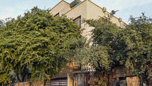 A residential building with a beige facade, satellite dishes, and a gated entrance. - OYO 19530 SilverKey Vishrantwadi (Pune)
