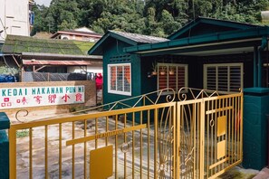 A small, green building with a sign reading "KEOAI MAKANAN PUNMI" and a yellow gate with "HEARTITUDE" written on it. - Heahtitude (Kampung Raja)
