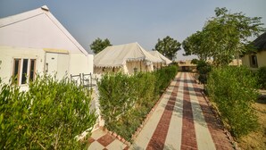 A pathway leading to a row of white tents with a checkered pattern. - OYO 24424 Kf Resorts Pvt Ltd (Jaisalmer)