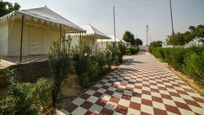 A pathway leading to a row of tents with a checkered floor. - OYO 24424 Kf Resorts Pvt Ltd (Jaisalmer)
