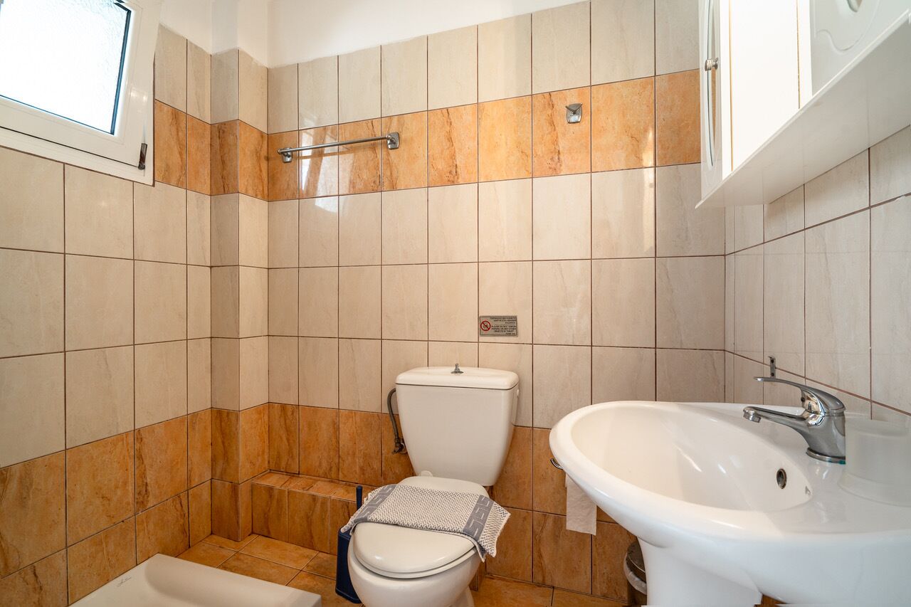 A bathroom with a toilet, bidet, and sink.