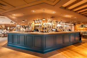 A spacious bar area with multiple bar stools and a central bar counter.