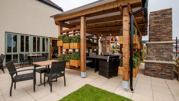 An outdoor patio area with wooden pergolas, tables, and chairs. - Canterbury Bell, Margate by Marston's Inns (Broadstairs)