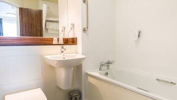 A modern bathroom with a white sink, toilet, and bathtub.