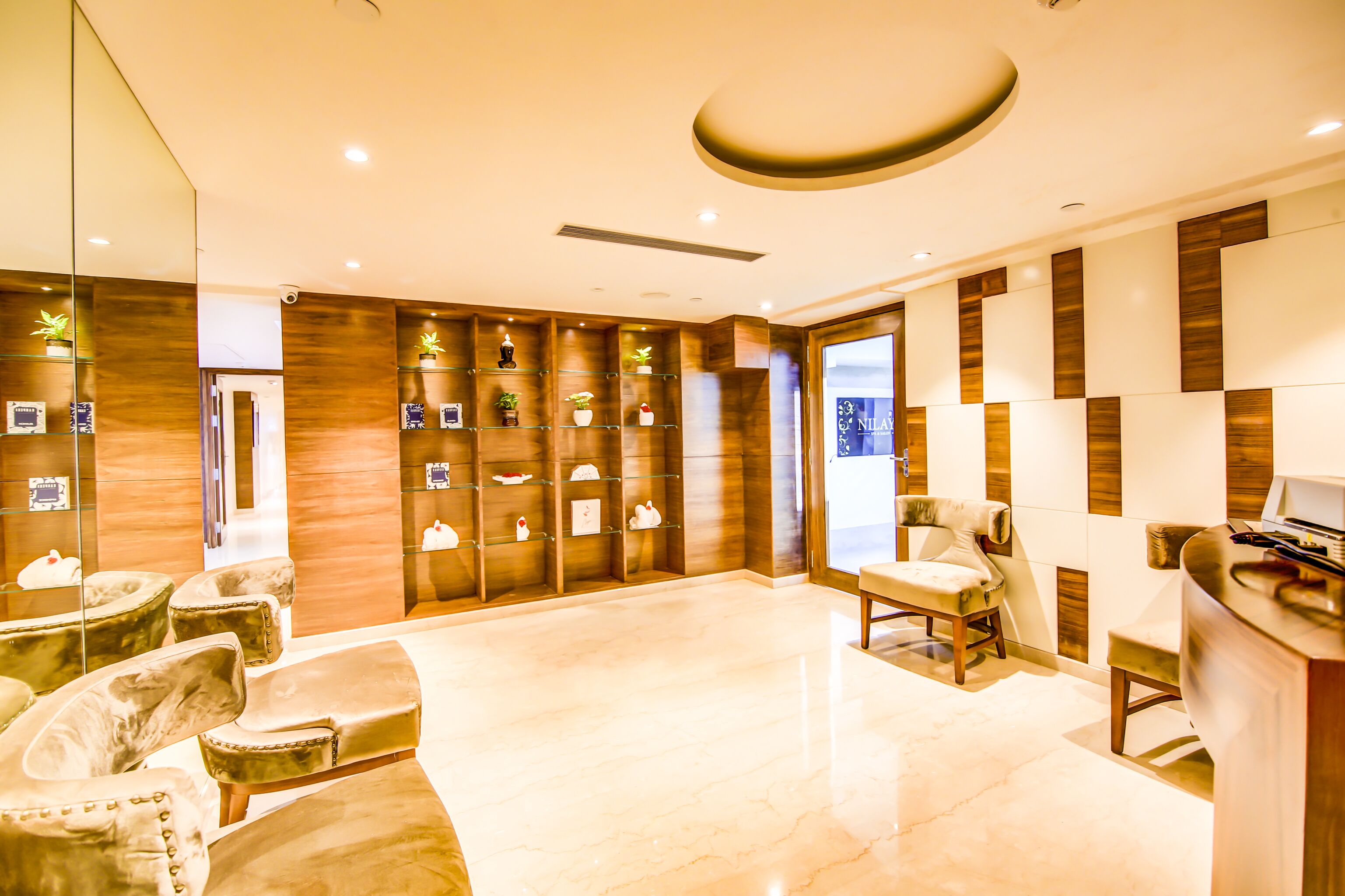 Un moderno vestíbulo de hotel con piso de mármol, paneles de madera y una recepción.