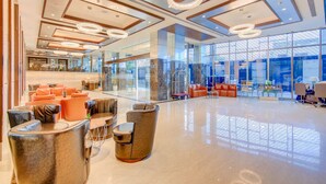Un vestíbulo amplio con muebles modernos, ventanas grandes e iluminación decorativa.