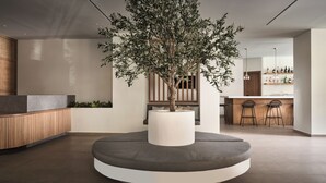 A modern interior with a central seating area, a wooden reception desk, and a bar area in the background. - Admiral De Luxe Hotel (Zakynthos)