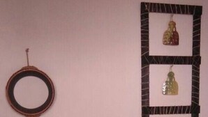 A living room with a teal sofa, a round mirror, and a decorative wall piece. - Chocolate, March (Martos)