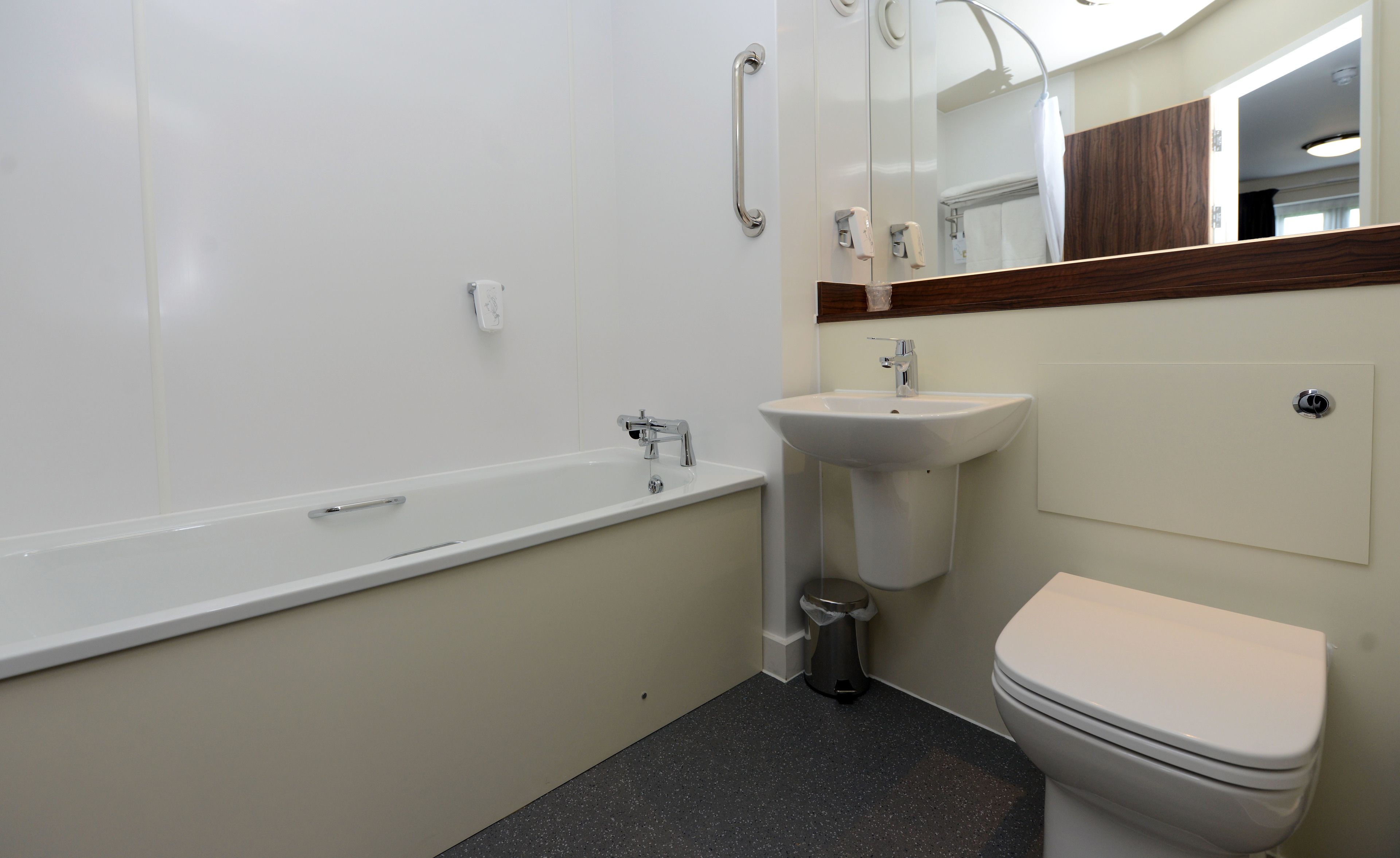 A bathroom with a white bathtub, a sink, and a toilet.
