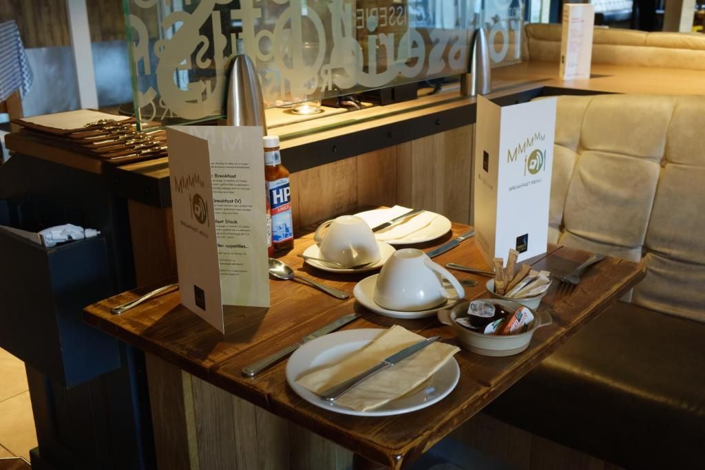 Una preparación para el desayuno con un atril de menú, una botella de agua HP y un letrero para el menú de desayuno.
