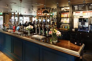 A bar area with multiple taps, a coffee machine, and a variety of bottles on shelves. - Fallow Field, Telford by Marston's Inns (Telford)