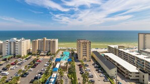 A hotel with a pool, parking lot, and ocean view. -  Crystal Tower Condos (Gulf Shores)
