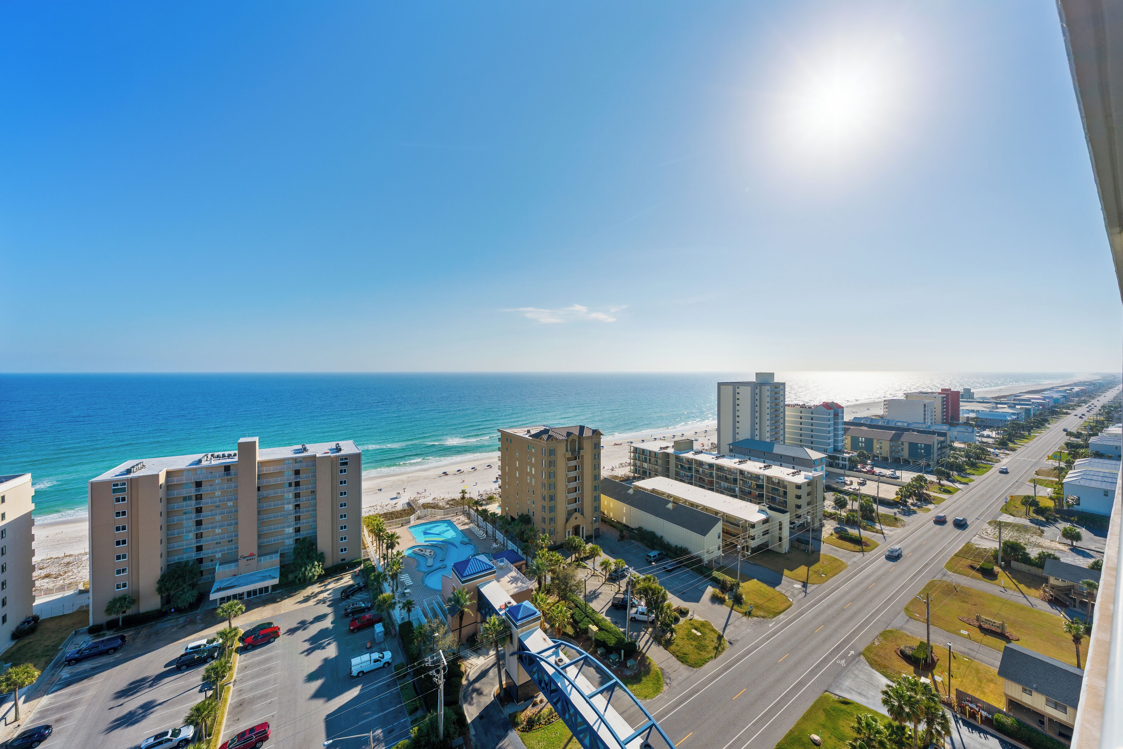 A coastal hotel with a pool, beach access, and a view of the ocean.