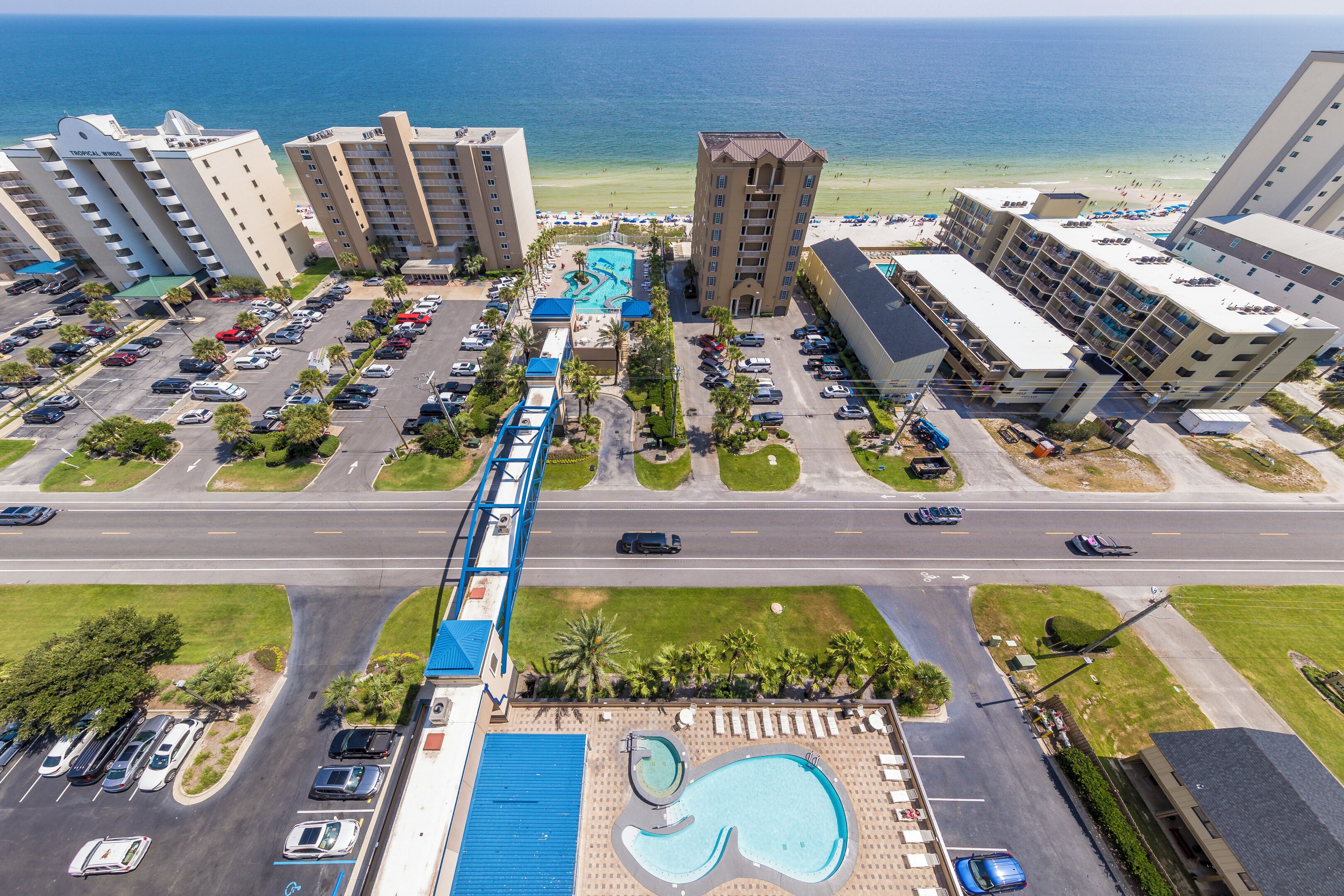 A hotel with multiple buildings, a swimming pool, and a parking lot.
