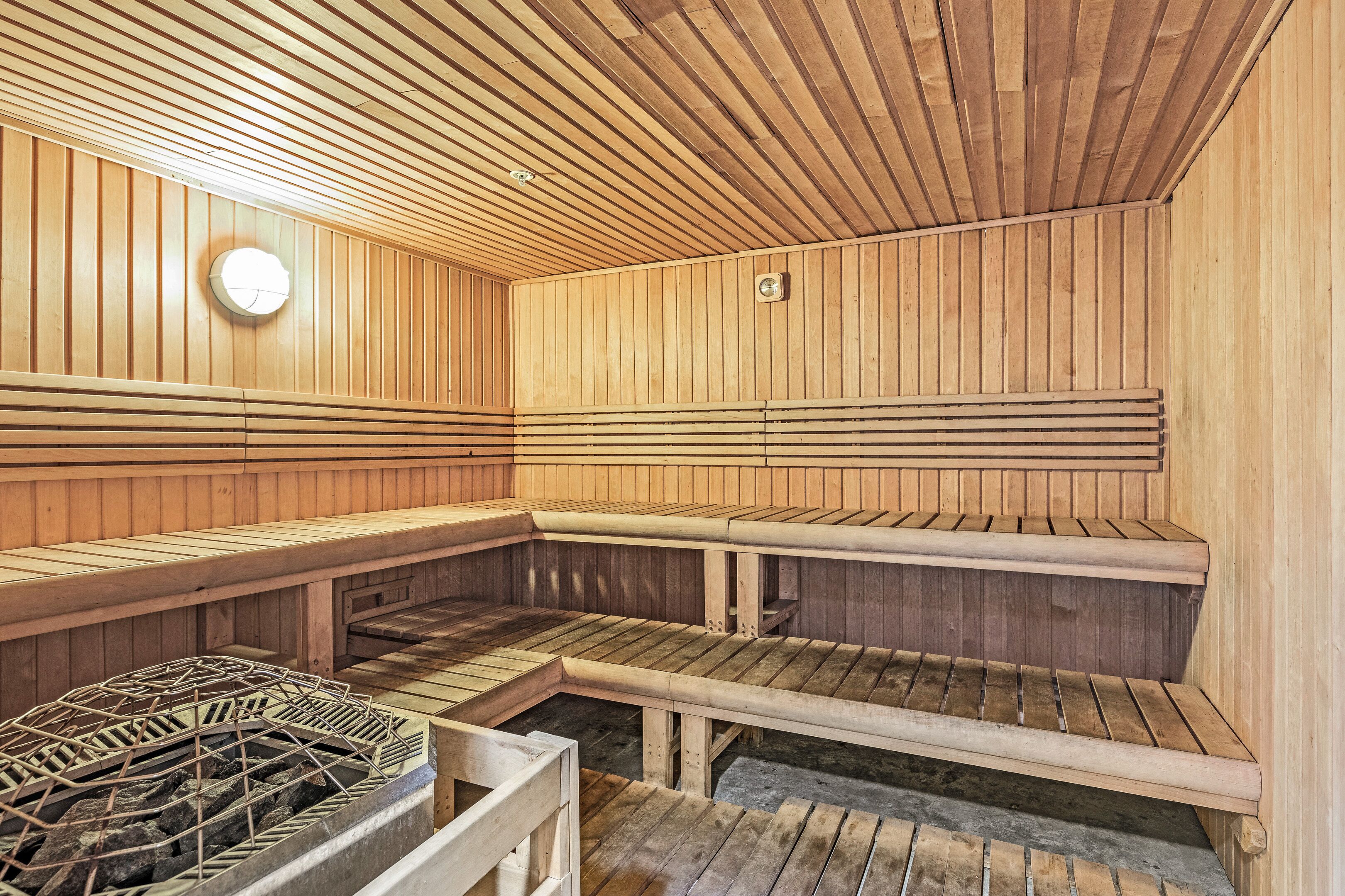 A sauna with wooden benches and a stone floor.