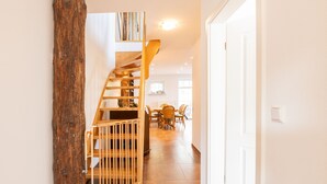 A staircase with wooden railings leading to a dining area with a table and chairs.