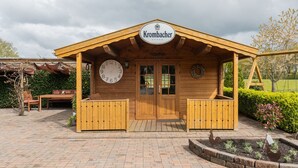 A wooden building with a sign reading "Krombacher".