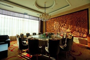A dining area with a round table, chairs, and a chandelier. - Xishan Hotel (Taiyuan)