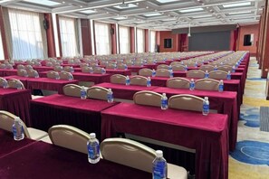 A conference room with rows of tables, each with a water bottle and a headrest. - Xishan Hotel (Taiyuan)