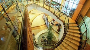 A multi-level atrium with glass railings, a central fountain, and a spiral staircase. - Xishan Hotel (Taiyuan)