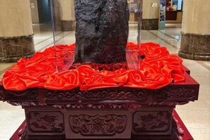 A statue on a pedestal with a red cloth. - Xishan Hotel (Taiyuan)
