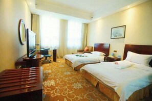 A hotel room with two beds, a desk, a chair, a TV, and a large mirror. - Xishan Hotel (Taiyuan)