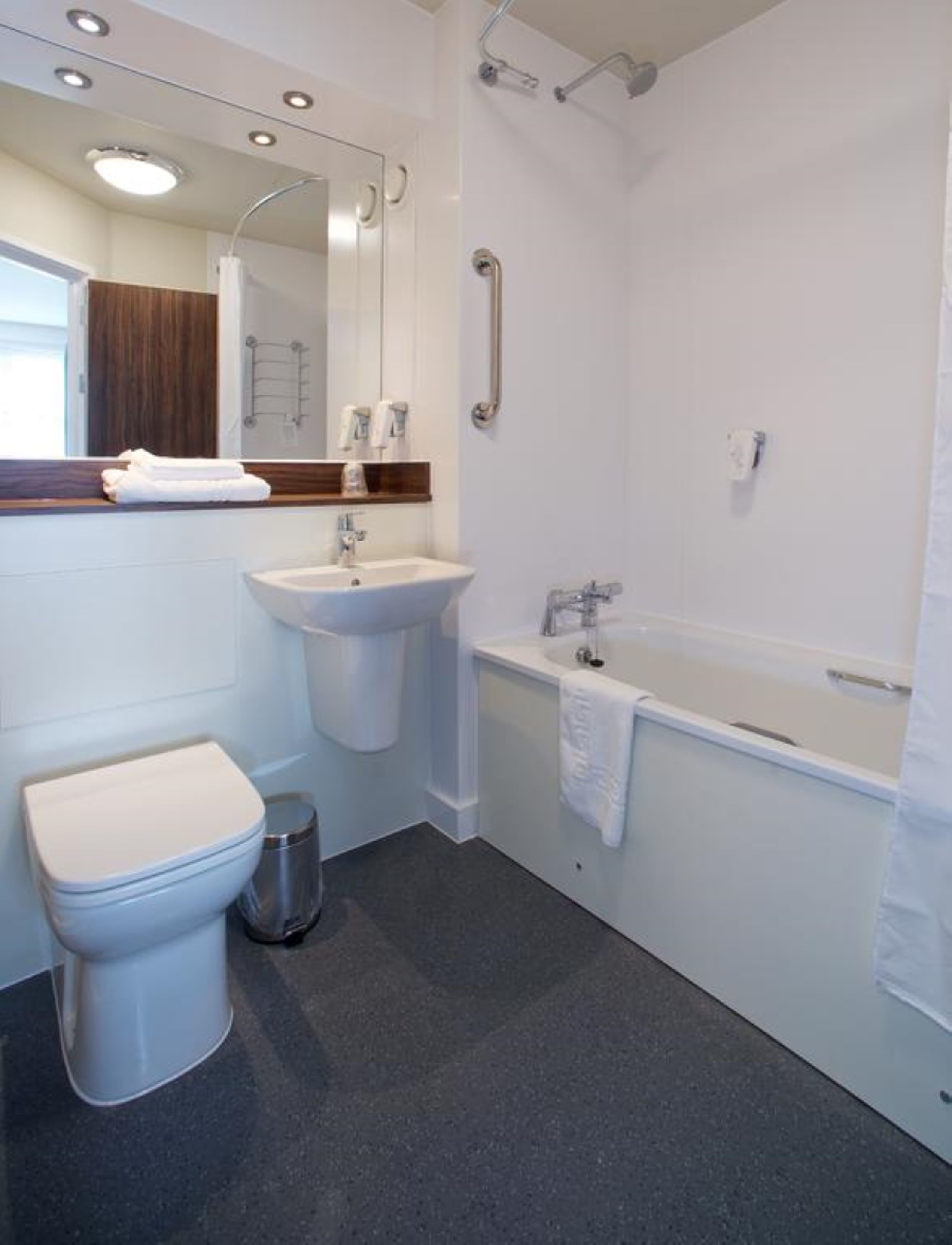 Un baño moderno con inodoro, lavamanos y bañera.