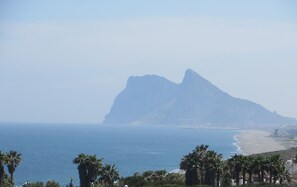 Un campo de golf con vista al océano y una montaña al fondo.