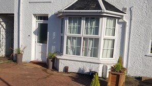 A white building with a bay window, a door, and a sign indicating a private driveway. - Oxford City Guest House (Oxford)