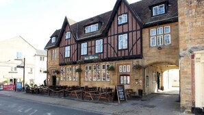 Un bâtiment traditionnel à colombages, sur lequel on peut lire l’inscription « Auberge de la Demi-Lune ».