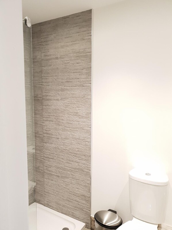 Un baño moderno con ducha, inodoro y bidé.