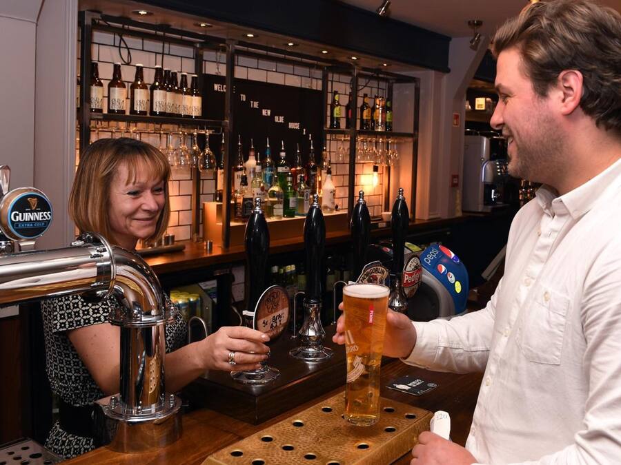 Un bar con múltiples grifos de cerveza, incluyendo Warsteiner y Guinness, y una variedad de botellas al fondo.