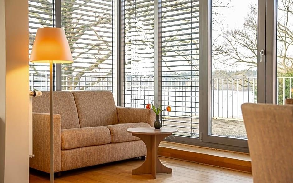 A room with a sofa, a small round table, and a lamp.