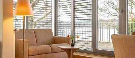 A room with a sofa, a small round table, and a lamp.