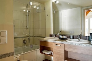 A modern bathroom with two sinks, a shower, and a mirror. - Hotel Seeblick (Friesoythe)