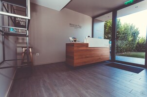 Una recepción con detalles de madera y un letrero que dice 'Hotel do Paco'.