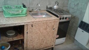 Eine kleine Küche mit Spüle, Gasherd und Backofen.