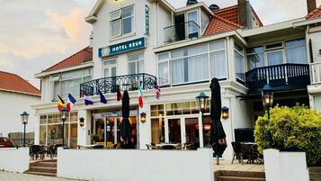 Step into the classic Hotel Keur, where a welcoming entrance with a balcony offers a glimpse of the street below.