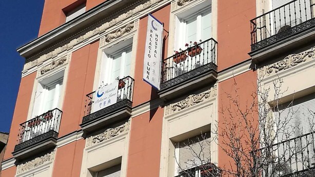 A building with multiple balconies, a sign for a hostel, and a sign for a hotel named "Hostal Luna". - Hostal Palacio Luna (Madrid)