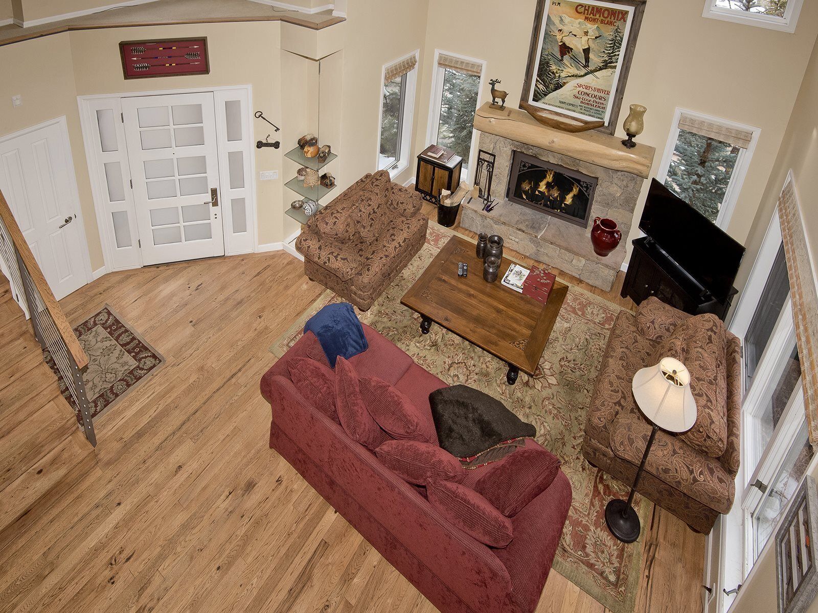 A living room with a fireplace, a television, and a red sofa.