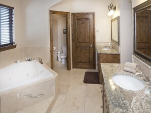 Ein Badezimmer mit einer großen Badewanne, einem Waschbecken und einer Toilette.