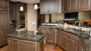 Una cocina moderna con encimeras de granito, electrodomésticos de acero inoxidable y muebles de madera.