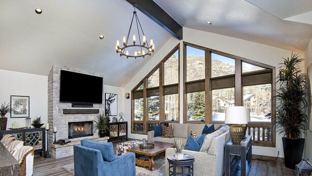 A spacious living room with a fireplace, large windows, and modern furniture. - Glacier Court 1854 A (Vail)