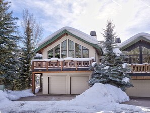 A two-story lodge with a balcony, large windows, and a garage.