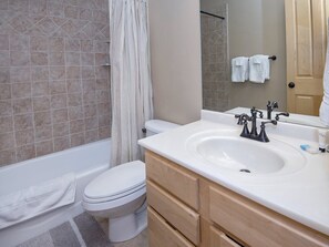 A bathroom with a bathtub, toilet, and sink.