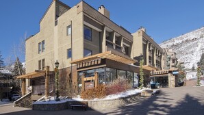 Un hôtel à plusieurs étages doté d’une architecture moderne, caractérisé par de grandes fenêtres et une façade en pierre.