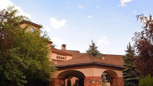 A building with a stone facade, arched entryway, and a tiled roof. - Arrowhead Village Condo - 104 Seasons Lodge (Edwards)