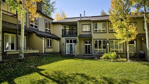 A two-story house with a front porch, a covered patio, and a well-maintained lawn.